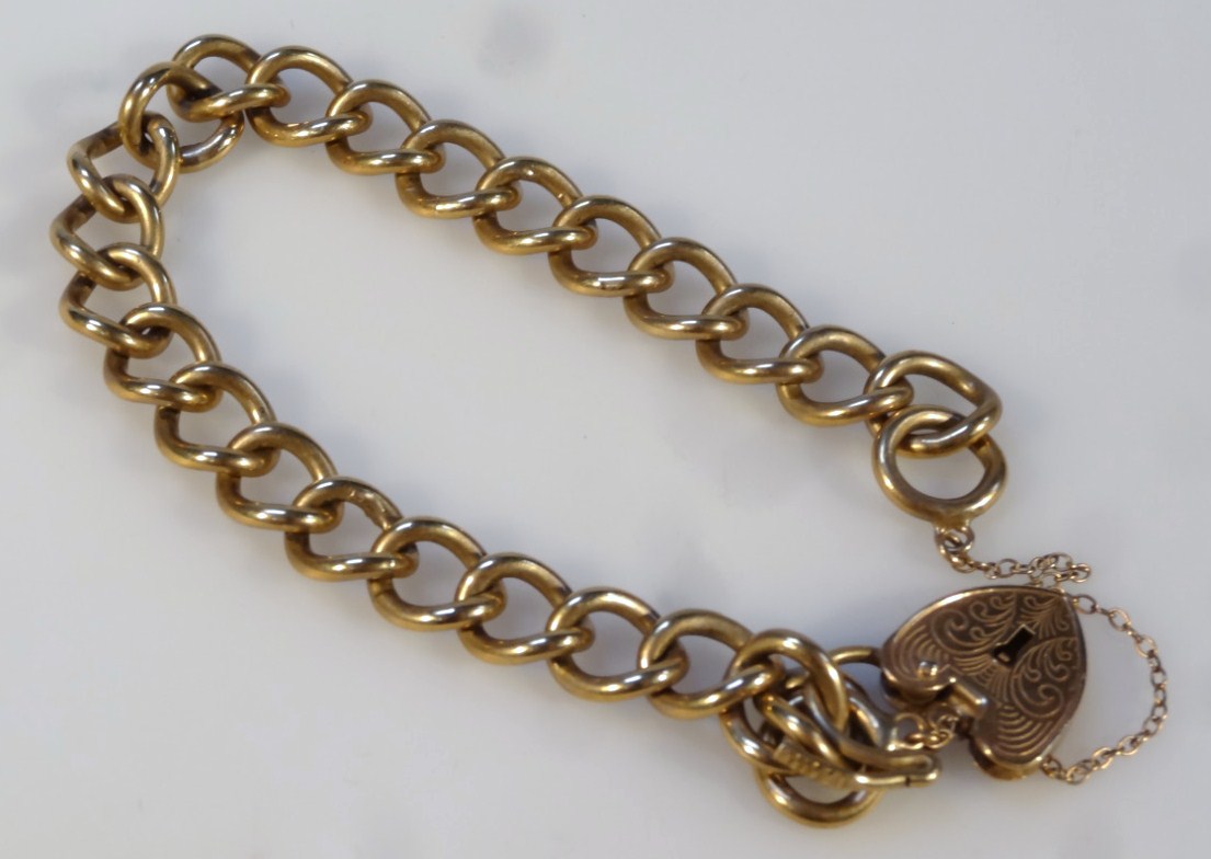 Appraisal: A curb link bracelet with heart shape padlock clasp marked