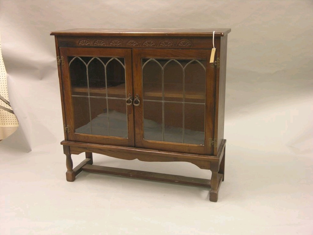 Appraisal: A reproduction dark oak bookcase enclosed by a pair of