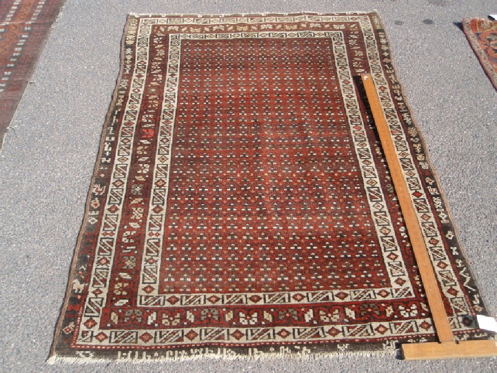 Appraisal: A red ground multi-gul and multi border rug cm x