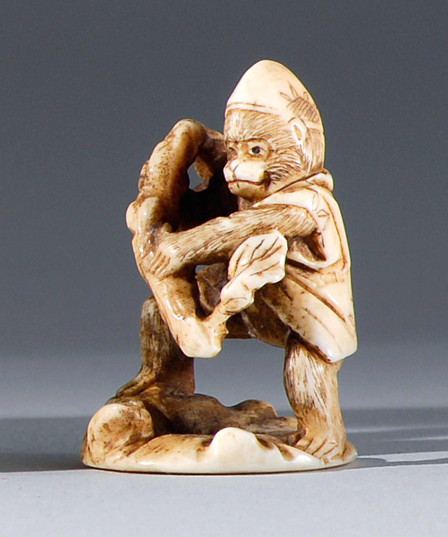 Appraisal: STAGHORN NETSUKE th CenturySigned Tomokazu Depicting a monkey holding a