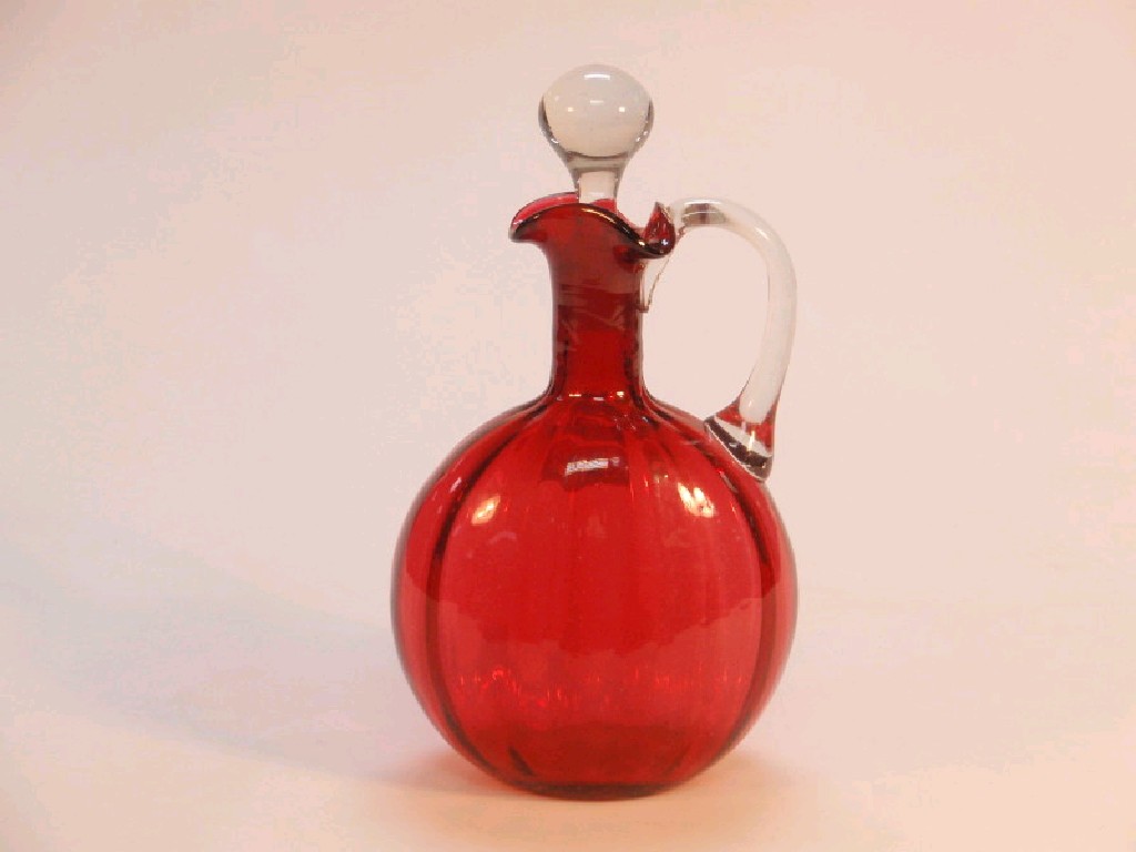 Appraisal: A cranberry glass decanter with clear stopper and handle with