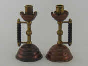 Appraisal: A pair of Arts and Crafts brass and copper candlesticks