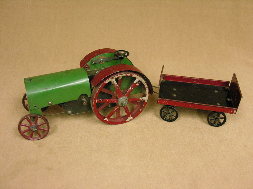 Appraisal: VINTAGE STRUCTO WIND-UP TRACTOR AND TRAILER Missing rear hub lock