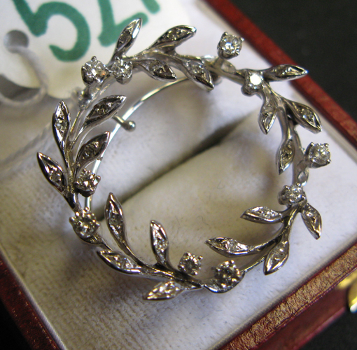 Appraisal: DIAMOND AND FOURTEEN KARAT WHITE GOLD PENDANT BROOCH the wreath