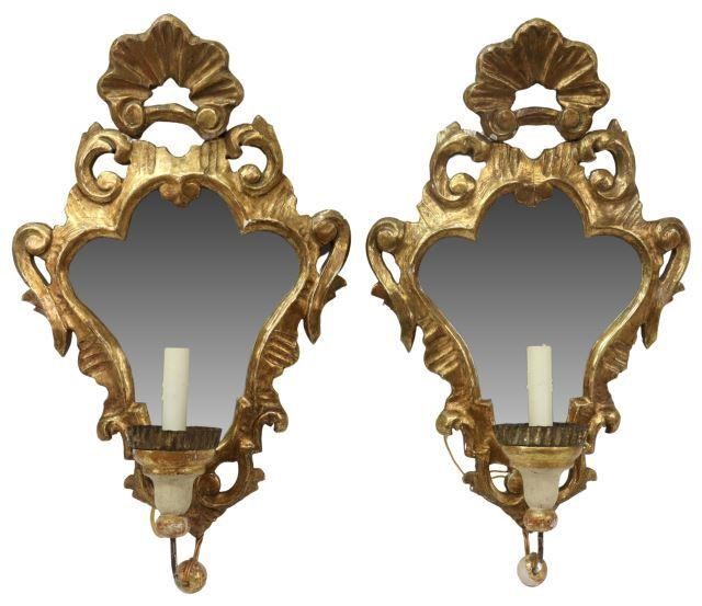 Appraisal: pair Florentine giltwood mirrored wall sconces carved foliate frame containing