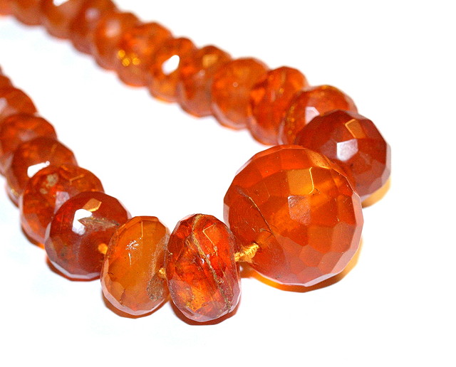 Appraisal: A GRADUATED FACETED AMBER BEAD NECKLACE cloudy sherry colour beads