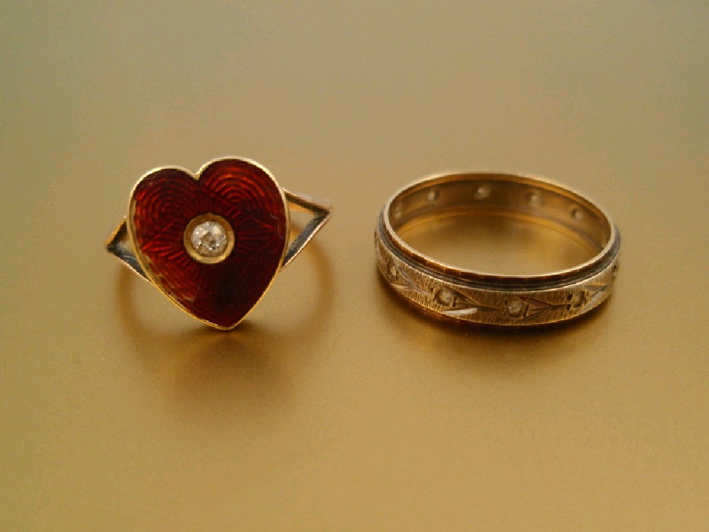 Appraisal: A heart shaped signet ring with red enamelled head set