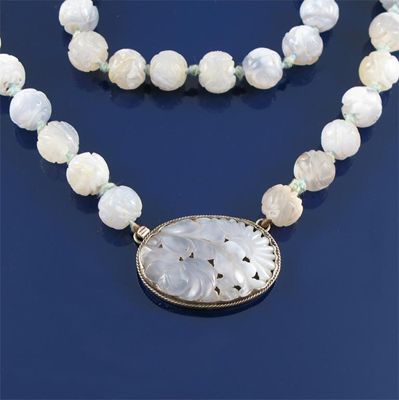 Appraisal: A carved lavender coloured hardstone necklace With a pierced and