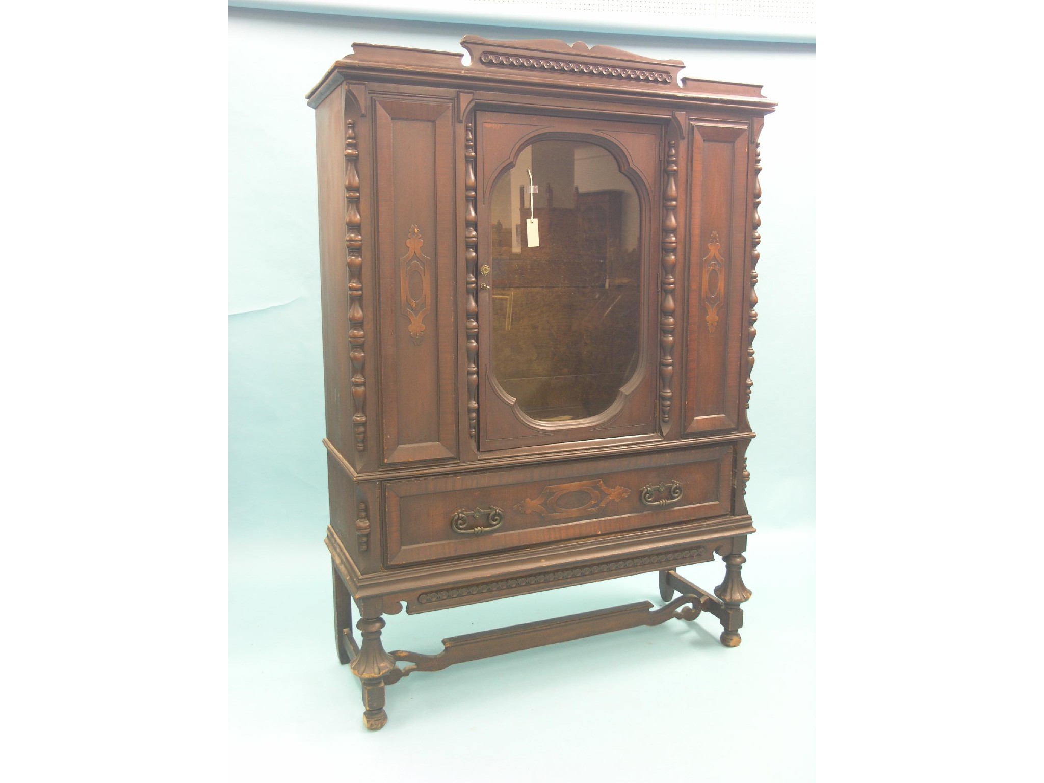 Appraisal: A large continental walnut display cabinet architectural-form with carved detail