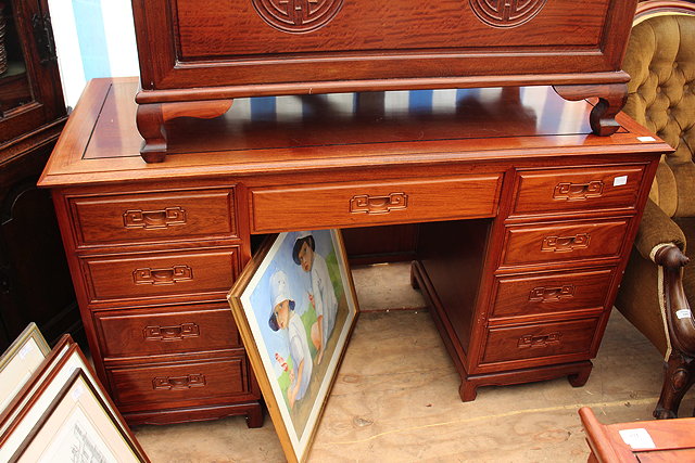 Appraisal: A CHINESE HARDWOOD PEDESTAL DESK with nine drawers around a