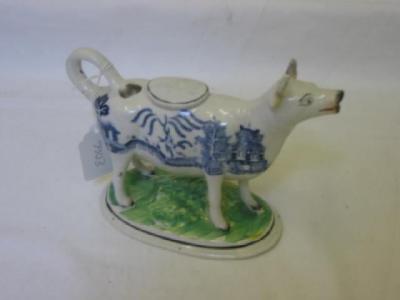 Appraisal: AN ENGLISH POTTERY COW CREAMER the looped tail forming a