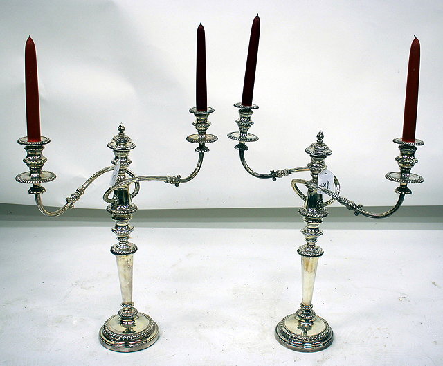 Appraisal: A PAIR OF SILVER PLATED TWO BRANCH CANDELABRA with gadrooned