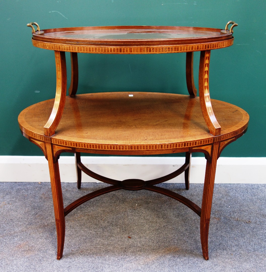 Appraisal: An Edwardian inlaid mahogany graduated oval two tier tray table