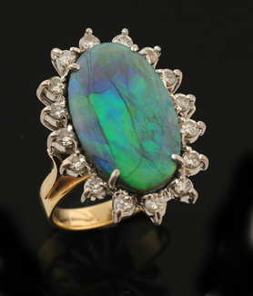 Appraisal: A black opal and diamond cluster ring The oval semi