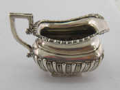 Appraisal: A silver cream jug of half ribbed barge shape with