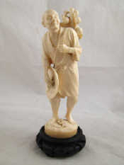 Appraisal: A Chinese ivory figure of a pedlar with fruit c