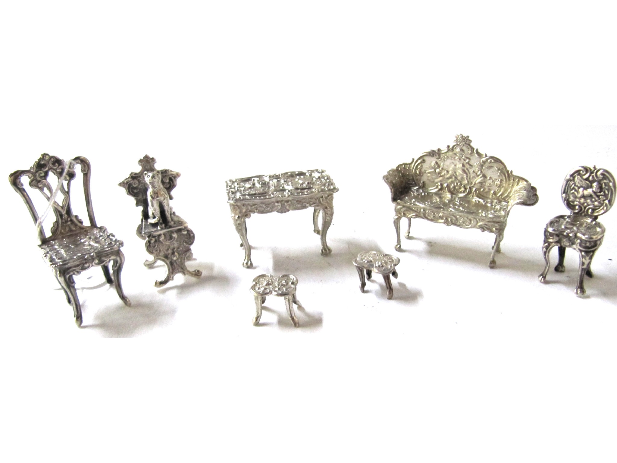 Appraisal: A lot comprising seven pieces of assorted miniature silver furniture