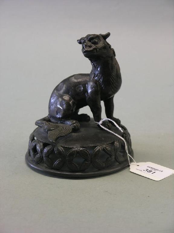 Appraisal: A Japanese bronze leopard recumbent animal upon pierced plinth in