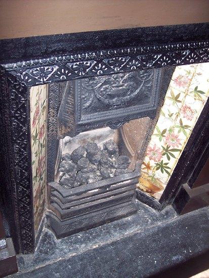 Appraisal: A Victorian cast iron fire surround with tiled panels flanking