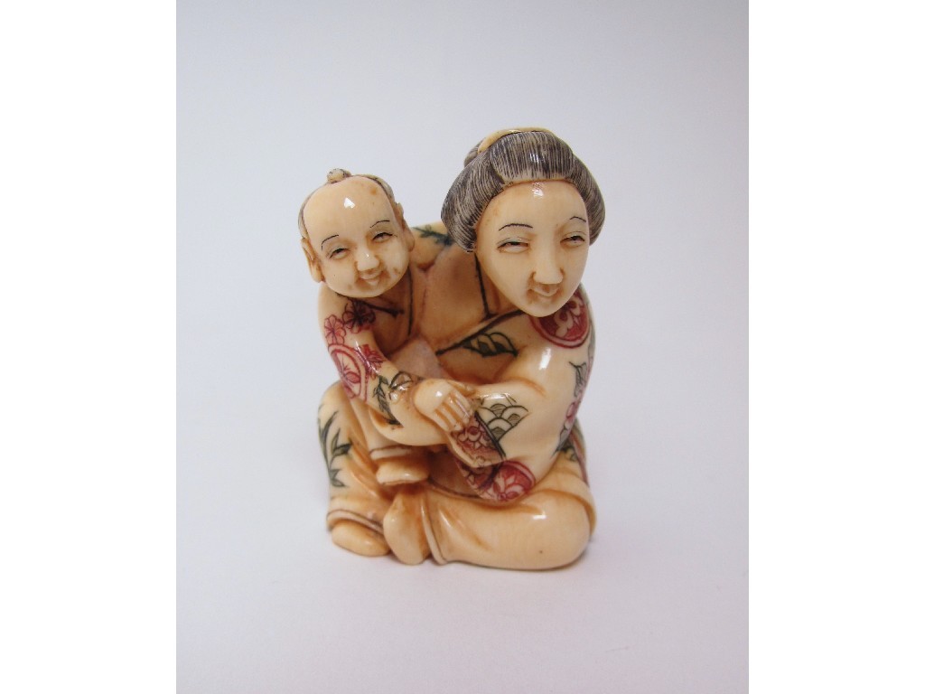 Appraisal: A Japanese ivory netsuke of a woman and child seated