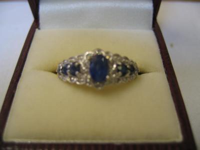 Appraisal: A SAPPHIRE AND DIAMOND DRESS RING comprising central sapphire flanked