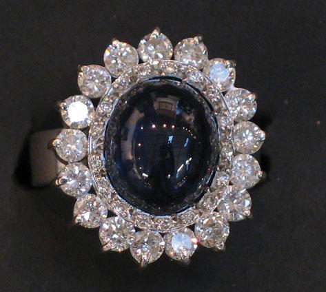 Appraisal: A SAPPHIRE AND DIAMOND CLUSTER DRESS RING the central cabochon