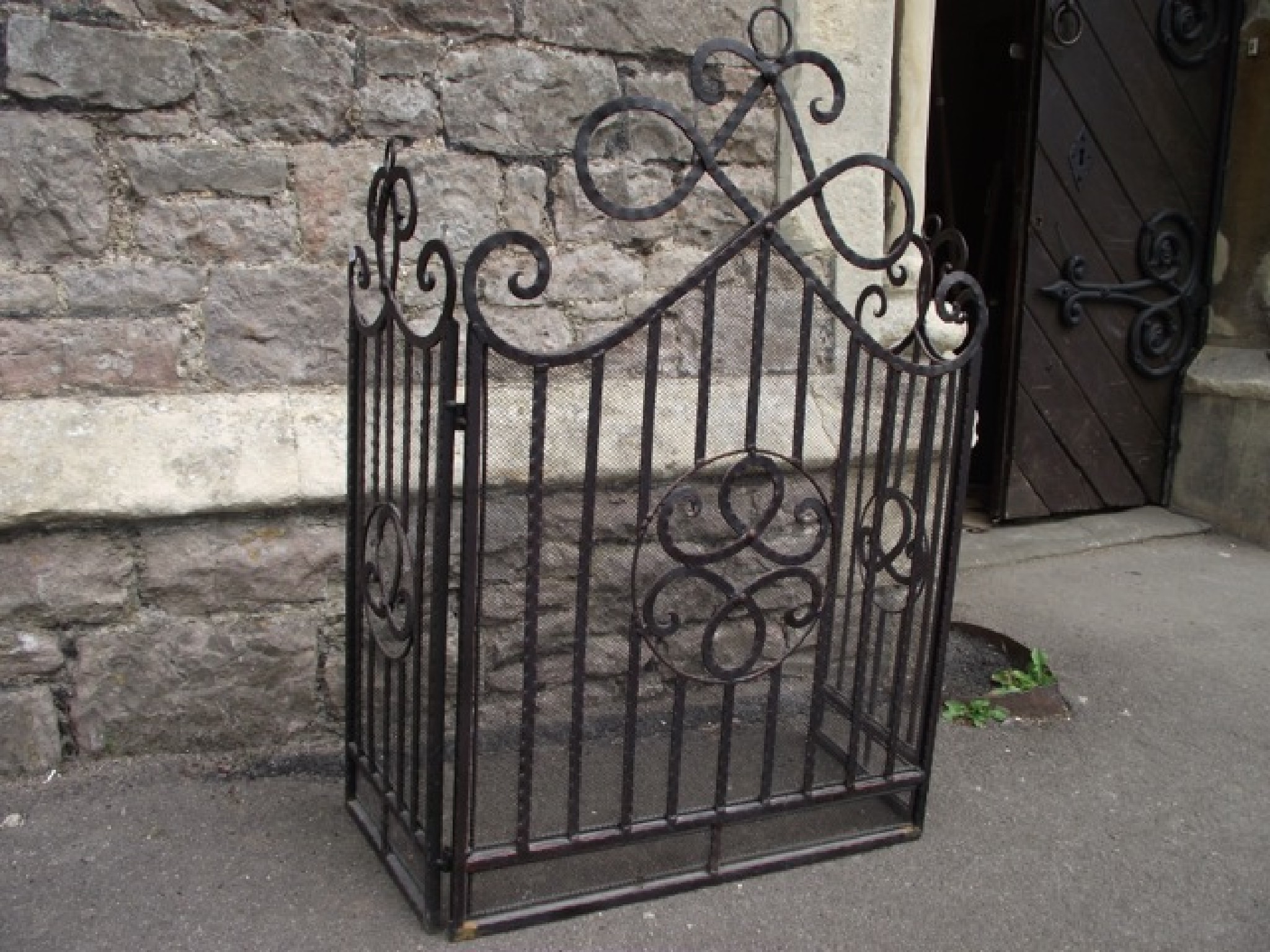 Appraisal: A three-fold ironwork fire spark guard with entwined scrollwork detail