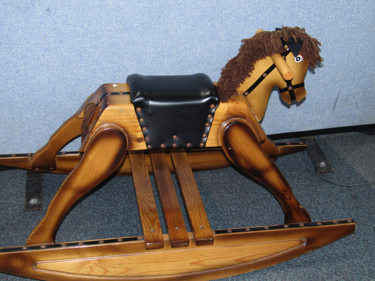 Appraisal: A pine rocking horse with a leather seat cm long