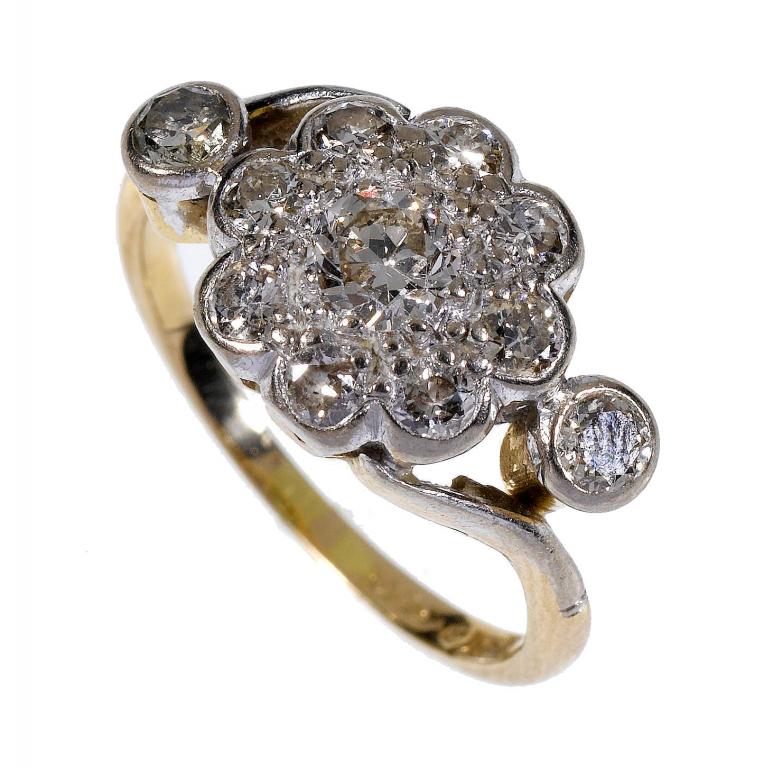 Appraisal: A DIAMOND CLUSTER RING with diamond collet to each shoulder