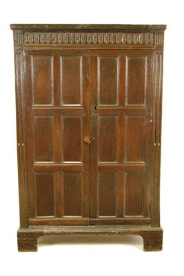 Appraisal: A panelled oak cupboard the lozenge carved frieze above a