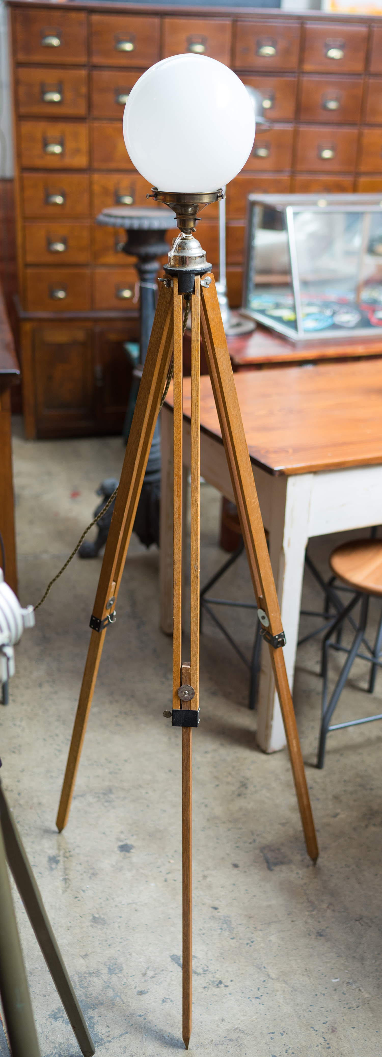 Appraisal: A VINTAGE INDUSTRIAL LIGHT ON TRIPOD BASE Milk glass shade