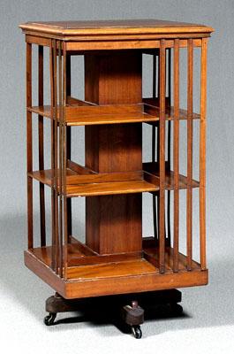 Appraisal: Walnut revolving bookcase stand walnut and mahogany swiveling above X