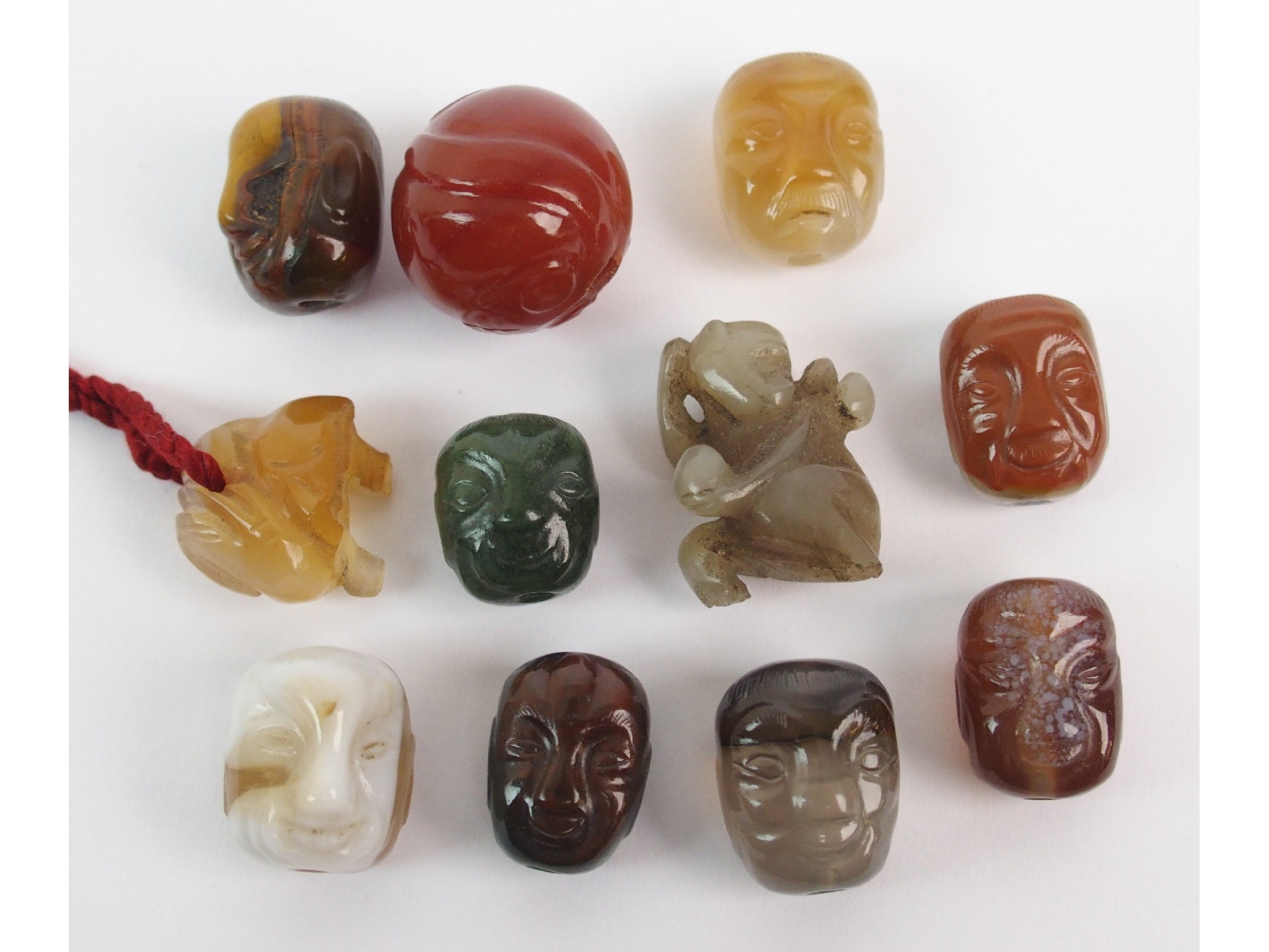 Appraisal: Eleven Japanese hardstone Ojimecarved as eight mask faces monkey ram