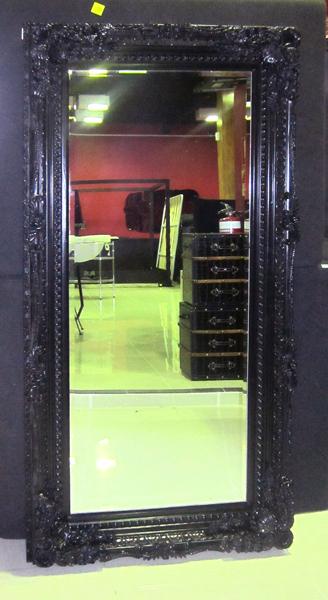 Appraisal: A HEAVILY CARVED EBONISED FRAMED MIRROR CM WIDE X CM