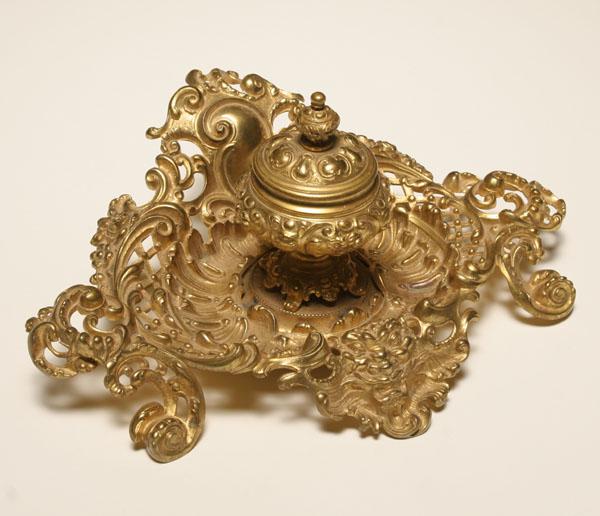 Appraisal: Elaborate brass inkwell with center well and menacing figural adornment