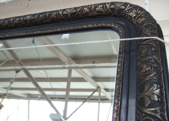 Appraisal: A th century black painted gesso overmantel mirror with parcel