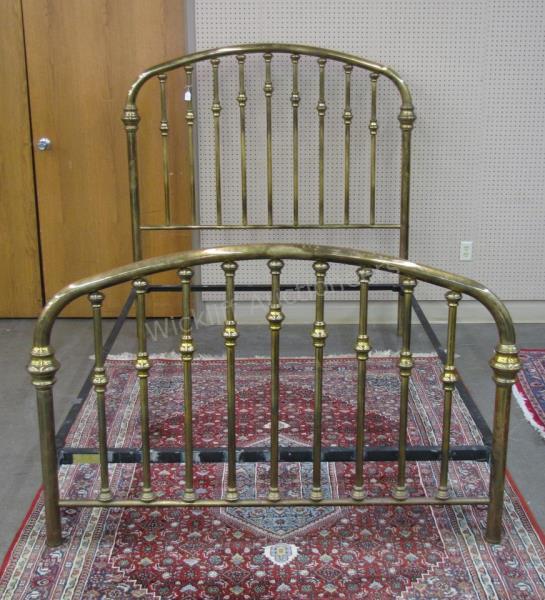 Appraisal: A vintage brass bed accommodates queen size bedding with metal