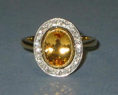 Appraisal: A YELLOW TOPAZ AND DIAMOND RING the Brazilian oval topaz