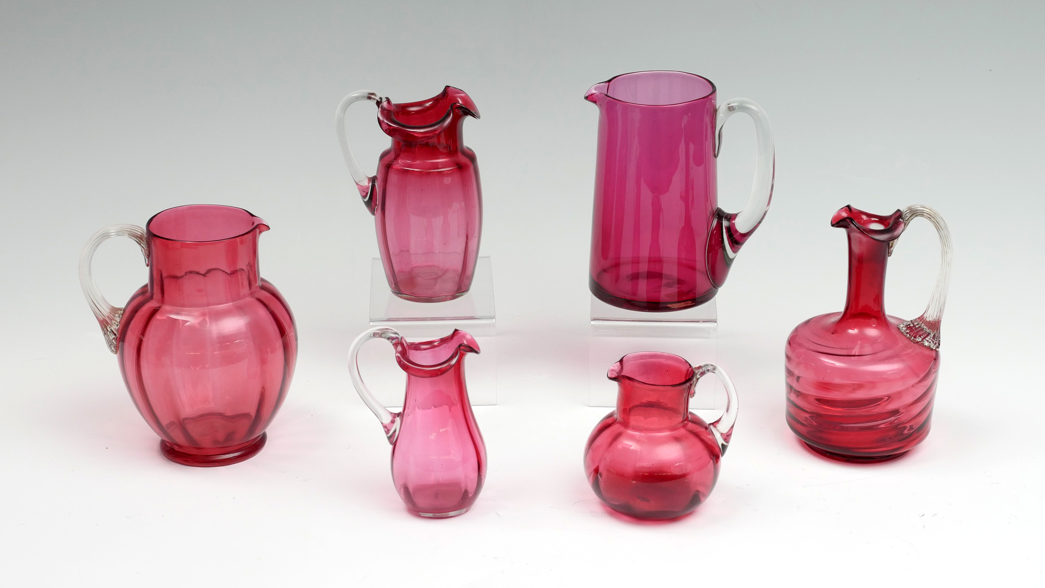 Appraisal: PC CRANBERRY ART GLASS PITCHERS - Paneled pitchers with applied