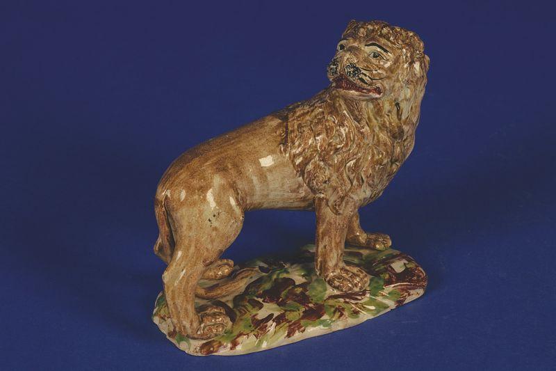 Appraisal: AN EARLY STAFFORDSHIRE POTTERY LION late th early th century