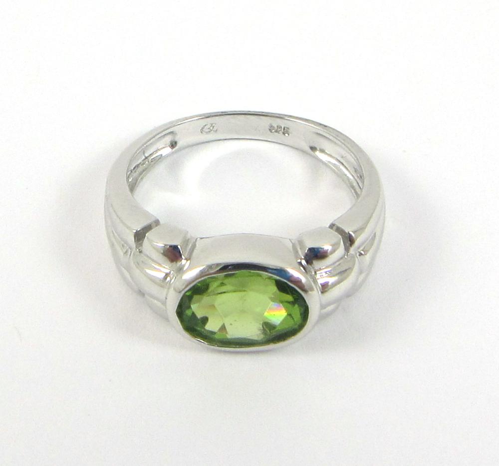 Appraisal: PERIDOT AND FOURTEEN KARAT WHITE GOLD RING bezel set with