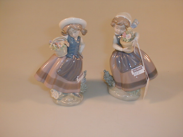 Appraisal: A pair of figurines of young girls holding flowers by