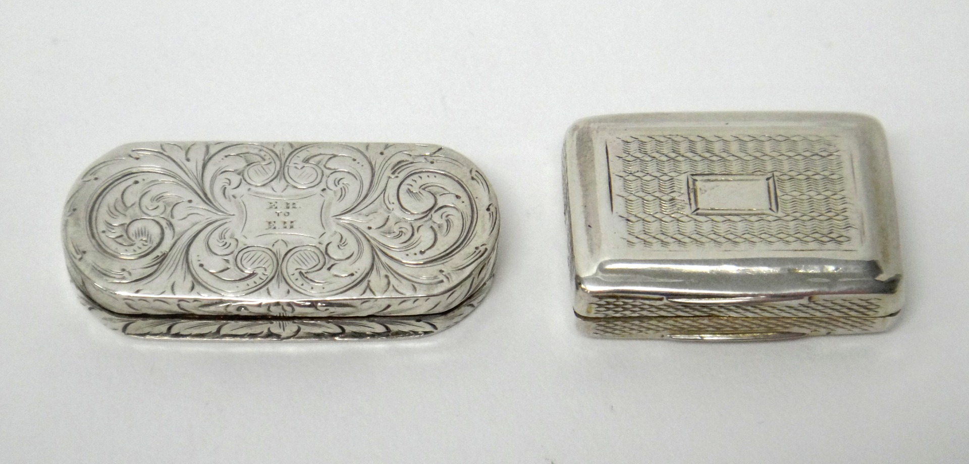 Appraisal: A Victorian silver curved rectangular vinaigrette with scroll engraved decoration