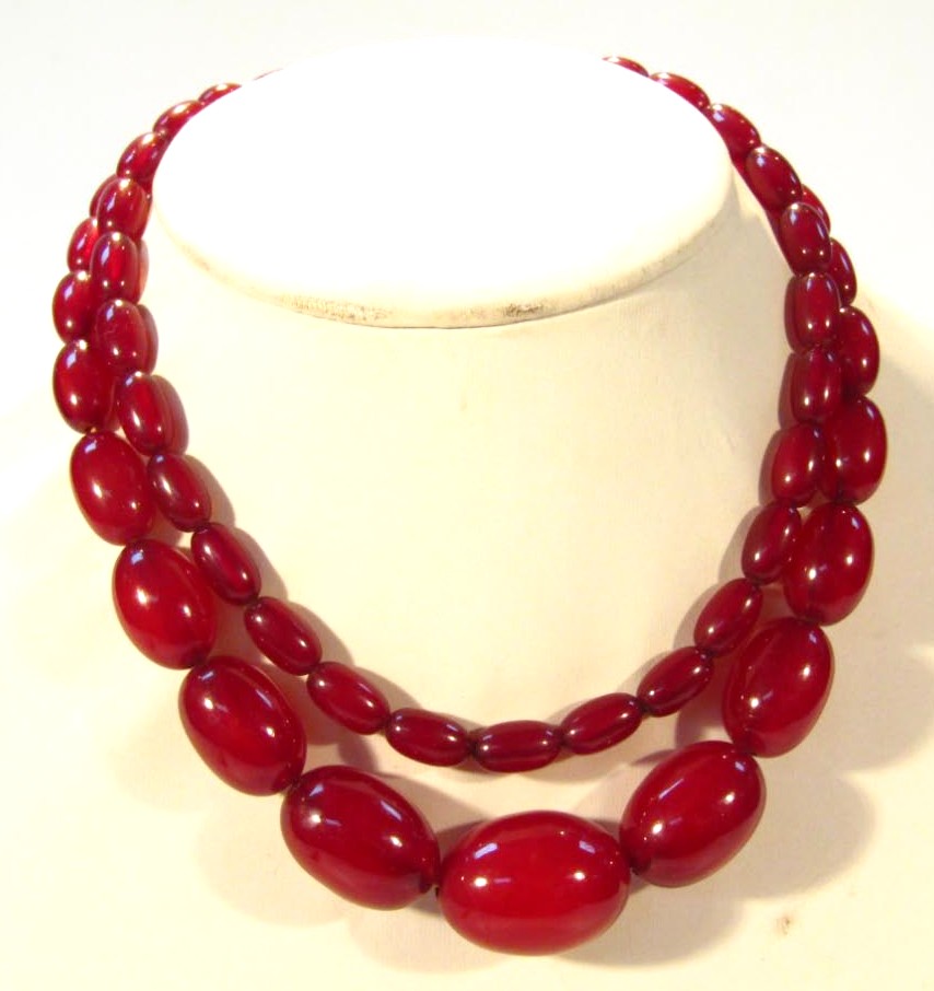 Appraisal: A string of red amber coloured beads each of graduated