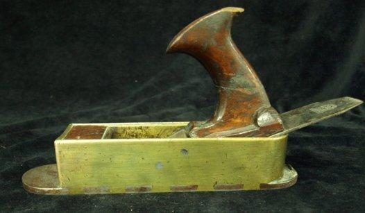 Appraisal: An early Victorian brass mounted smoothing plane with fruitwood mounts