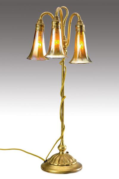 Appraisal: TIFFANY STUDIOS Three-light Lily lamp with a fluted base in