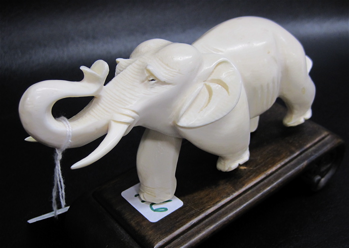 Appraisal: CARVED IVORY ASIAN ELEPHANT with upraised trunk attached to shaped