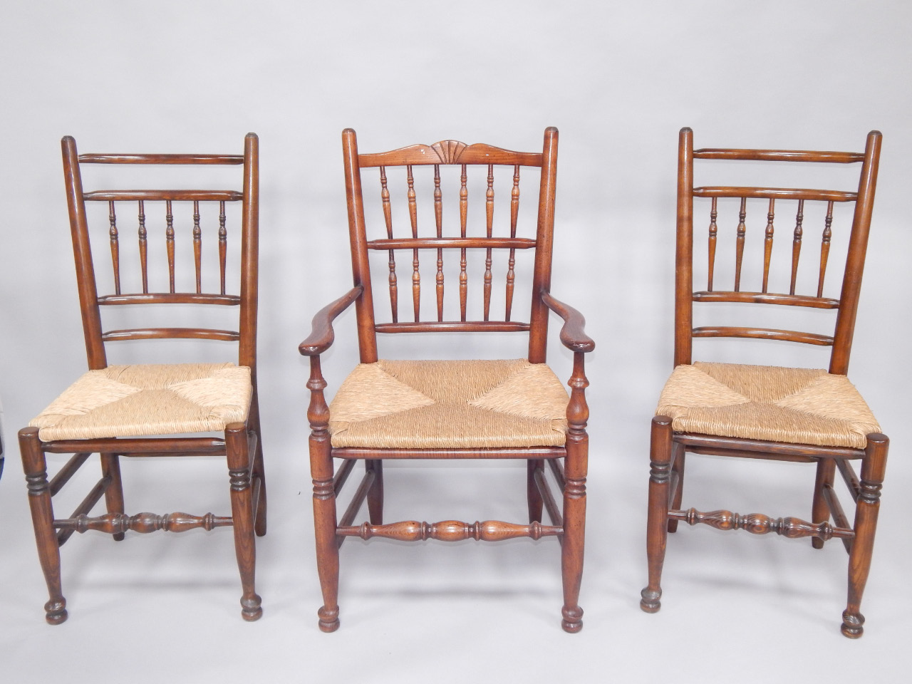 Appraisal: Three ash and oak spindleback chairs with rush seats raised