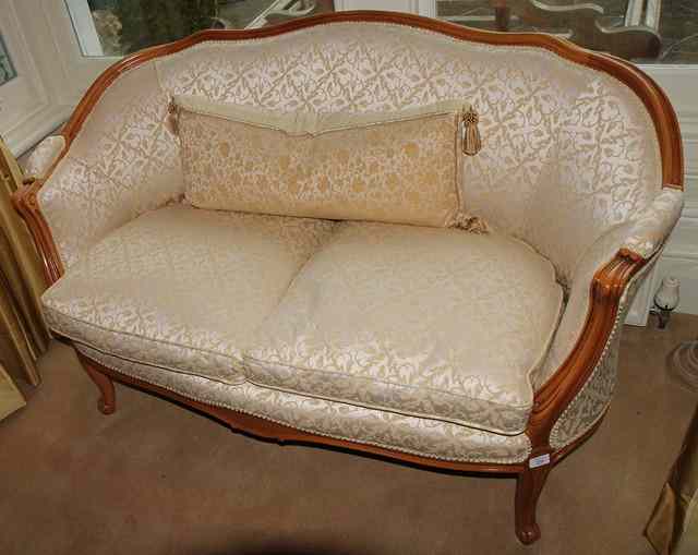 Appraisal: A FRENCH BEECHWOOD FRAMED SMALL SOFA with rounded back scrolling