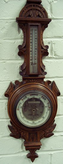 Appraisal: An Edwardian carved oak aneroid barometer cm high